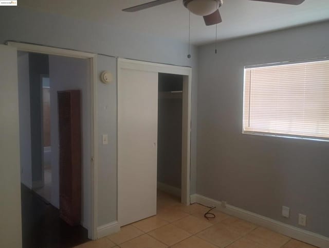 unfurnished bedroom featuring light tile patterned floors, a closet, and ceiling fan