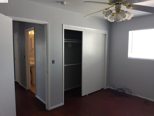 unfurnished bedroom featuring ceiling fan, dark hardwood / wood-style flooring, and a closet