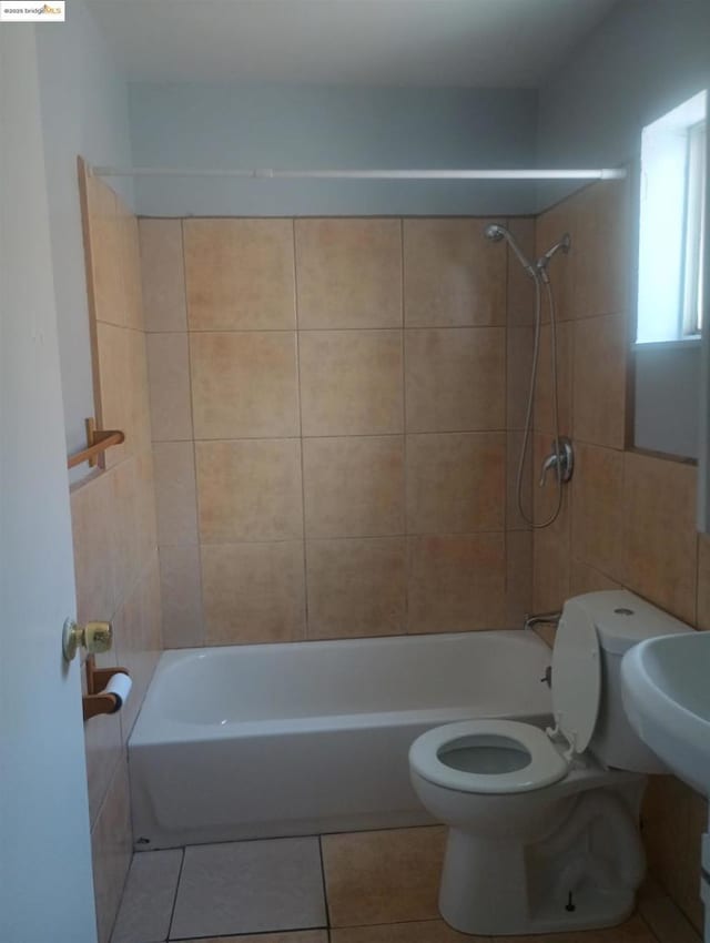 bathroom featuring tile patterned floors, toilet, and tiled shower / bath