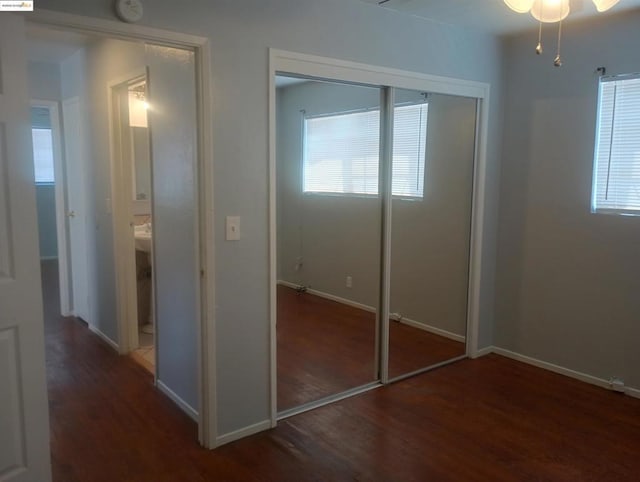 unfurnished bedroom featuring a closet and dark hardwood / wood-style floors