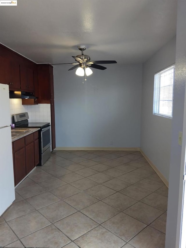 kitchen featuring light tile patterned flooring, tasteful backsplash, stainless steel electric range oven, white fridge, and ceiling fan