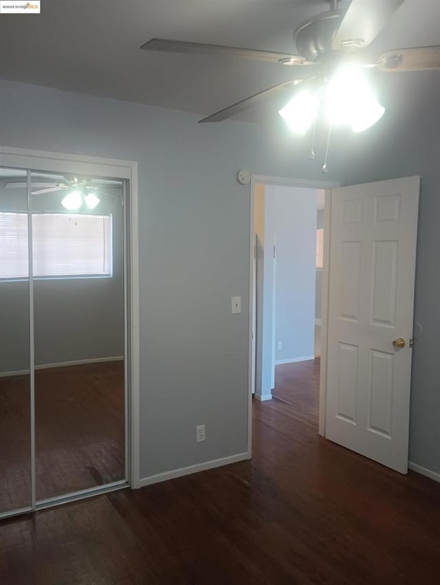 unfurnished bedroom featuring ceiling fan, dark hardwood / wood-style flooring, and a closet