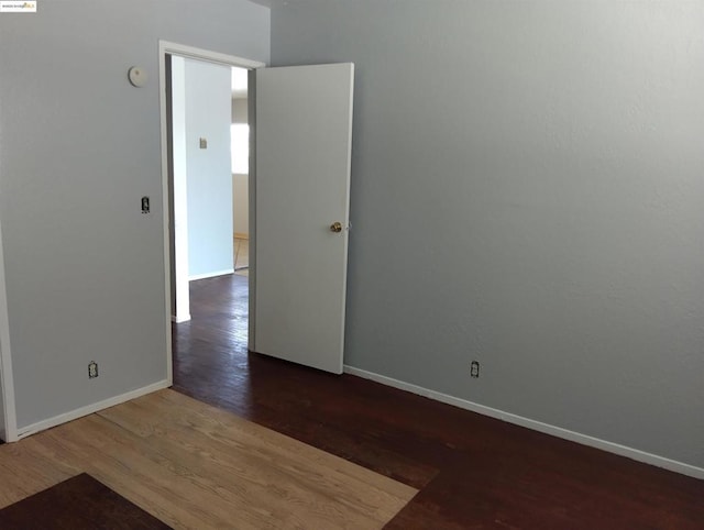 unfurnished room featuring dark wood-type flooring