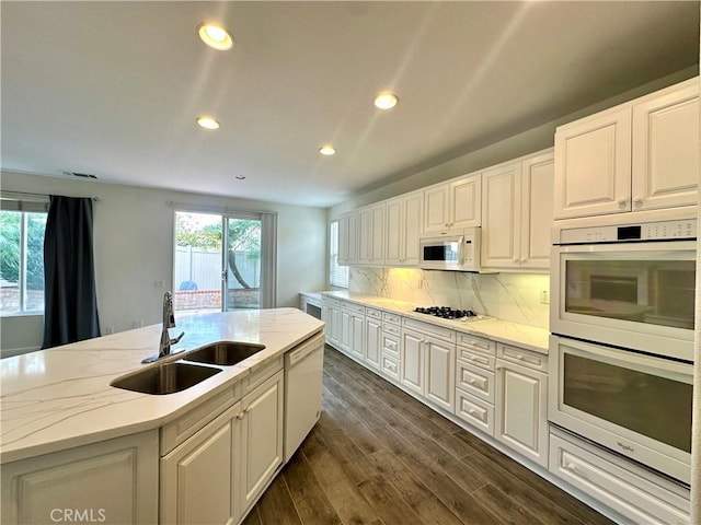 kitchen featuring white cabinetry, sink, backsplash, and white appliances