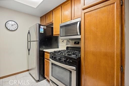 kitchen featuring stainless steel appliances and light tile patterned flooring