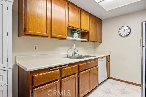 kitchen featuring dishwasher, sink, and stainless steel fridge