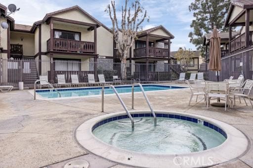 view of swimming pool with a patio area and a hot tub