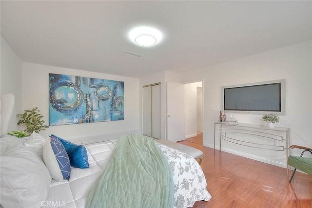 bedroom with wood-type flooring and a closet