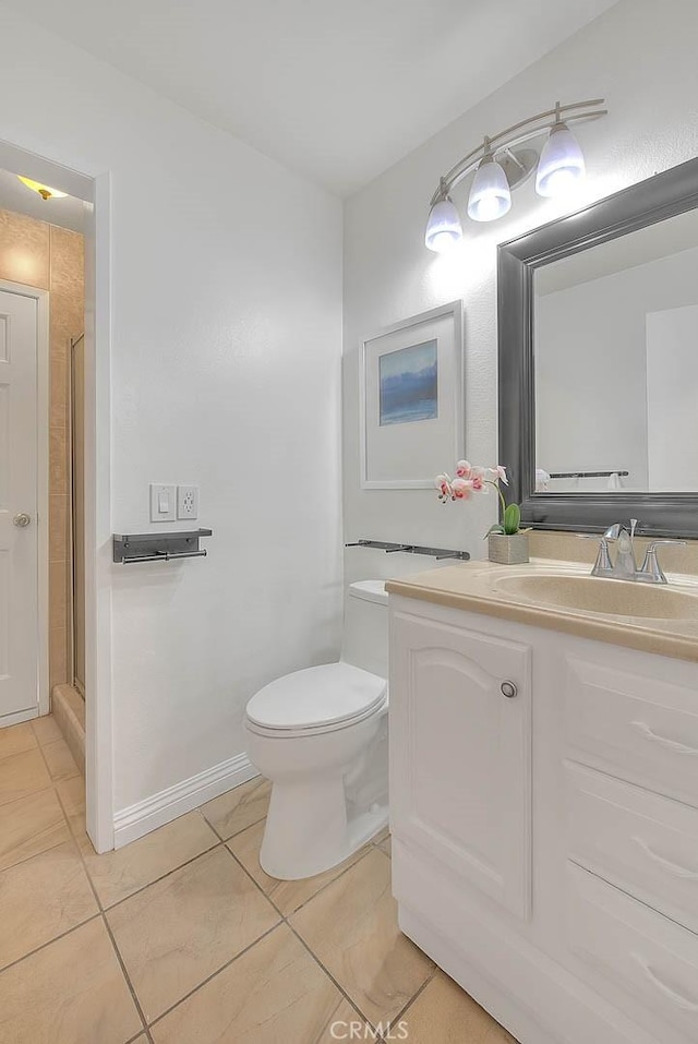 bathroom featuring tile patterned flooring, vanity, toilet, and walk in shower