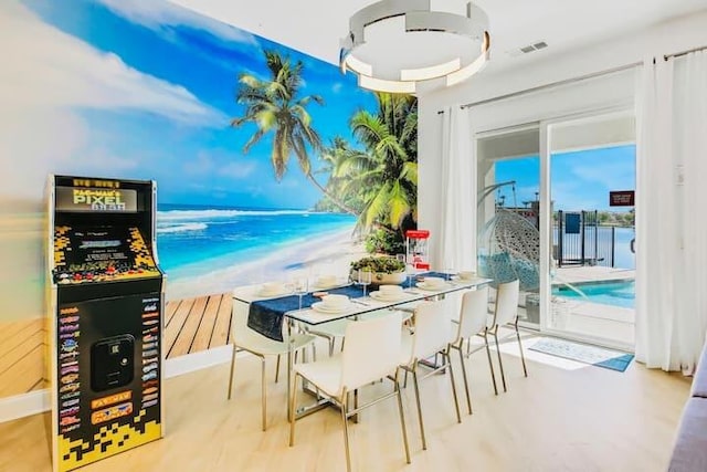 dining area featuring a water view, wood-type flooring, and plenty of natural light