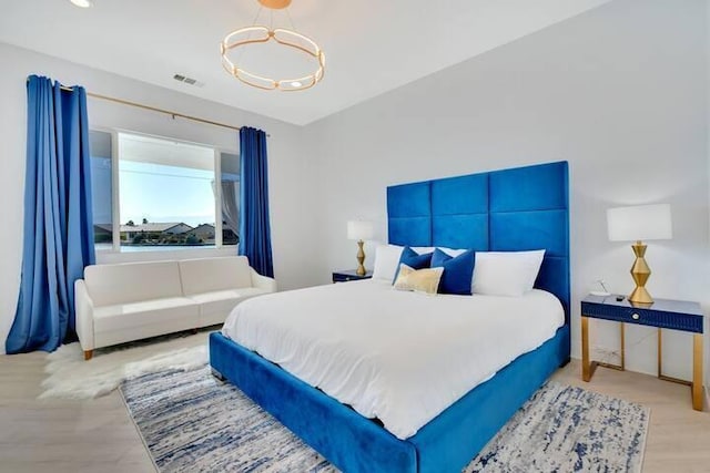 bedroom with a notable chandelier and light hardwood / wood-style flooring