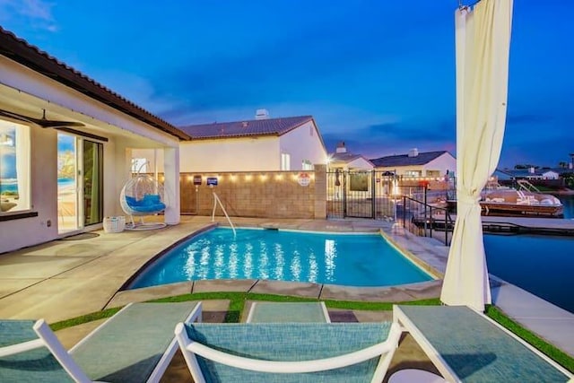 pool at dusk featuring a patio area