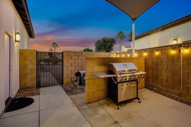 patio terrace at dusk featuring grilling area