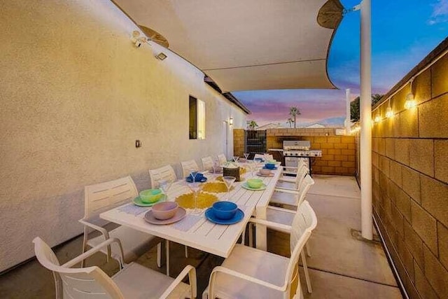 patio terrace at dusk featuring area for grilling