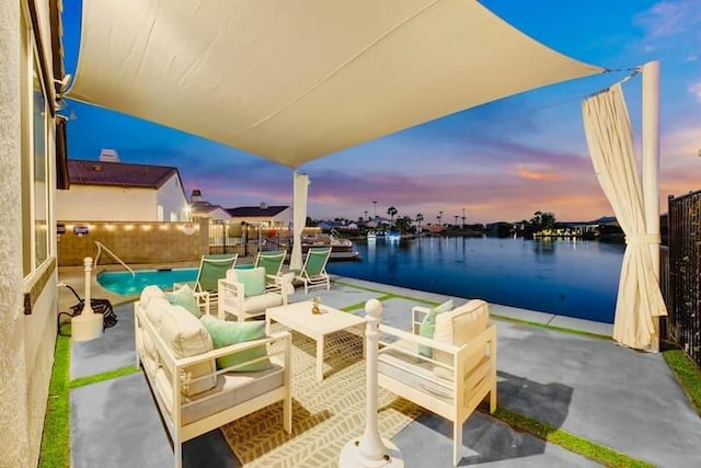 patio terrace at dusk featuring an outdoor living space, a fenced in pool, and a water view