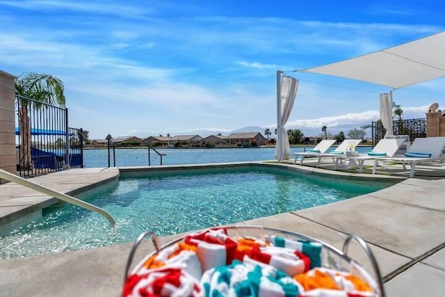 view of swimming pool featuring a water view and a patio area