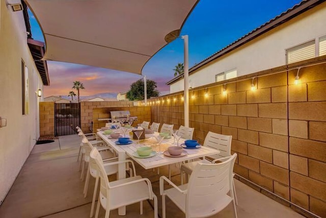 patio terrace at dusk featuring grilling area