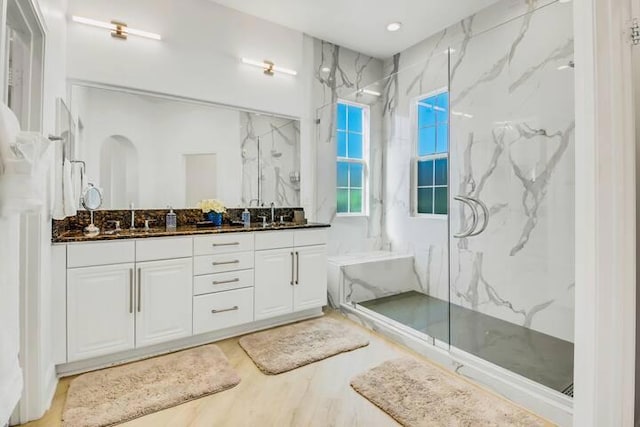 bathroom featuring vanity, a shower with shower door, and wood-type flooring