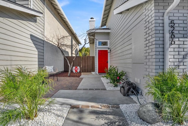 view of exterior entry with a patio area