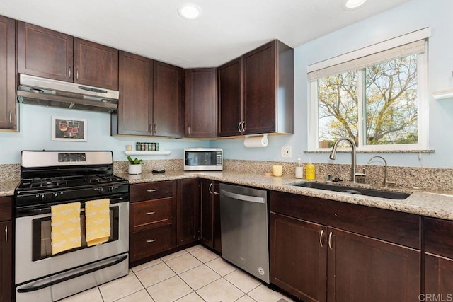 kitchen with light stone countertops, appliances with stainless steel finishes, and sink