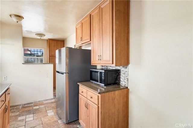 kitchen with appliances with stainless steel finishes and backsplash