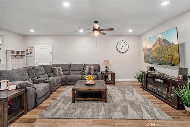 living room with light hardwood / wood-style flooring and ceiling fan