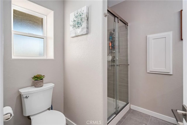 bathroom with an enclosed shower, tile patterned floors, and toilet