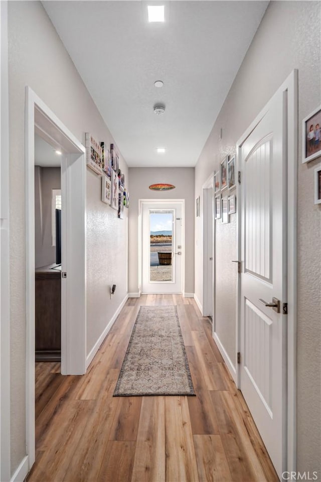 corridor with light hardwood / wood-style floors