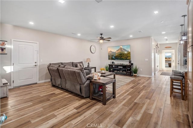 living room with ceiling fan and light hardwood / wood-style floors