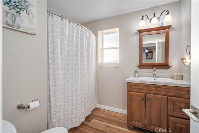 bathroom with hardwood / wood-style flooring, vanity, and toilet