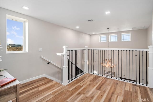 corridor featuring hardwood / wood-style flooring and a notable chandelier