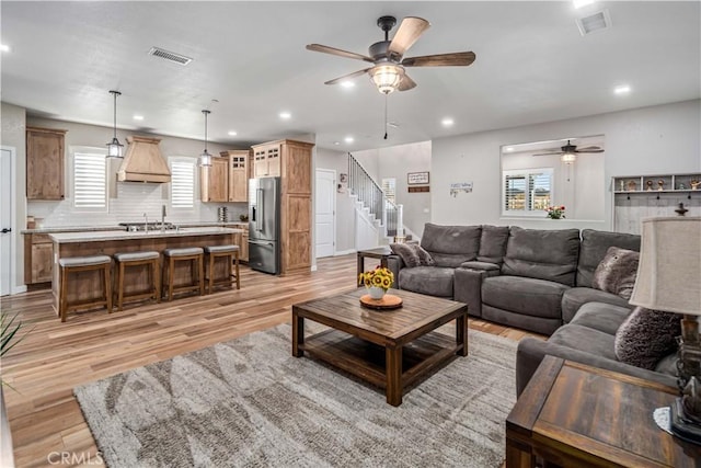 living room with ceiling fan and light wood-type flooring