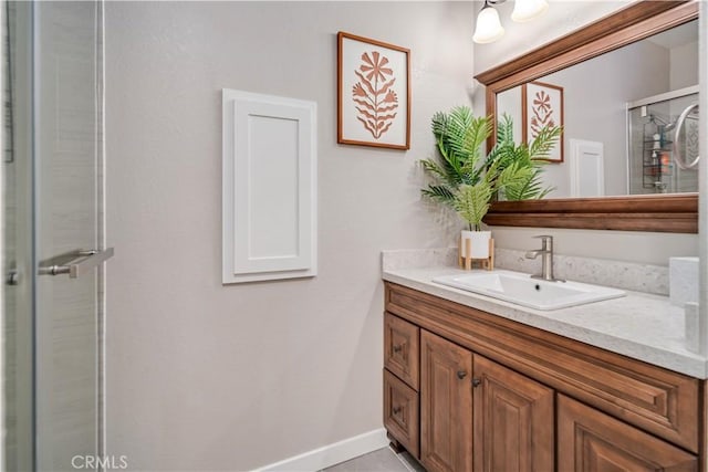 bathroom featuring a shower with door and vanity