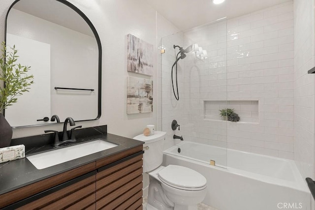 full bathroom featuring vanity, tiled shower / bath combo, and toilet