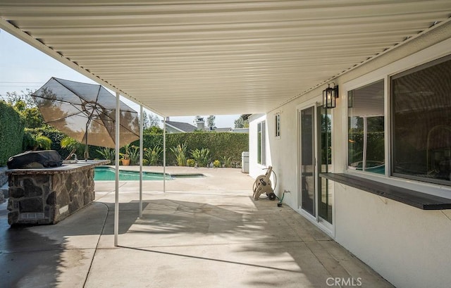 view of patio with area for grilling and a fenced in pool