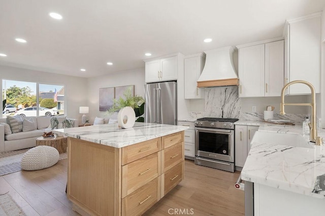 kitchen with custom exhaust hood, white cabinetry, a center island, and stainless steel appliances