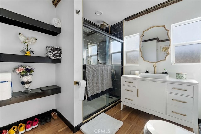 bathroom with hardwood / wood-style flooring, ornamental molding, vanity, and walk in shower