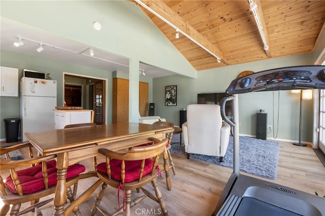 dining area with rail lighting, vaulted ceiling with beams, wood ceiling, and light hardwood / wood-style flooring