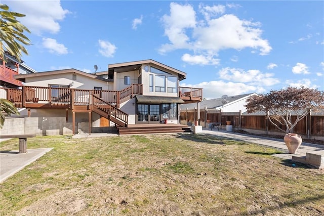 back of property featuring a deck and a lawn