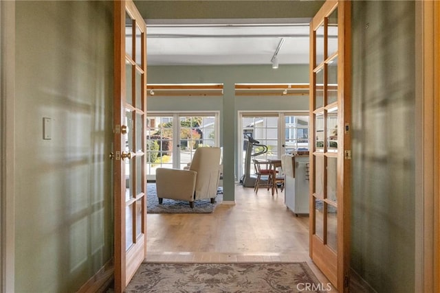 hall featuring light wood-type flooring and french doors