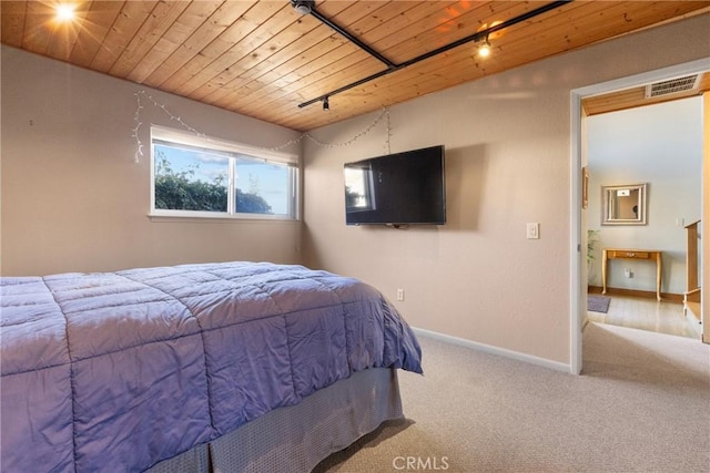 carpeted bedroom featuring wooden ceiling and rail lighting