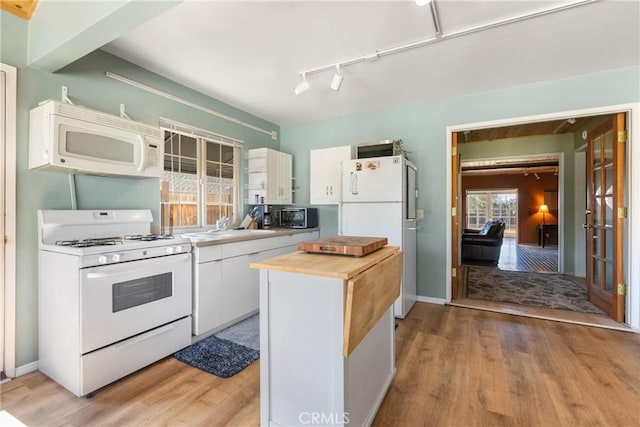 kitchen featuring butcher block counters, sink, light wood-type flooring, white appliances, and white cabinets