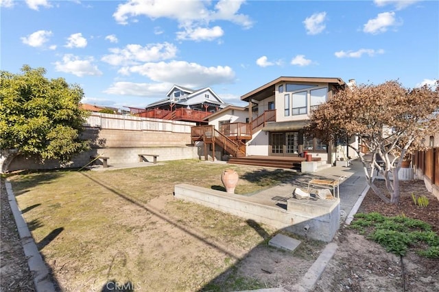 rear view of house with a patio and a lawn