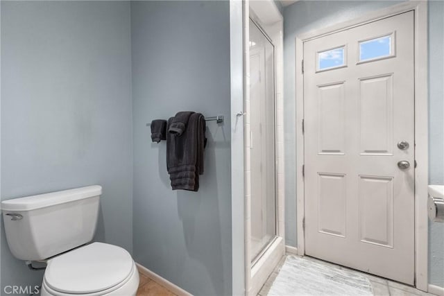 bathroom with a shower with shower door and toilet