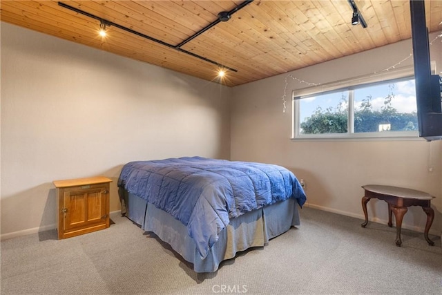 carpeted bedroom with wood ceiling and track lighting