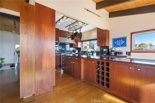 kitchen featuring vaulted ceiling with beams, wooden ceiling, and light hardwood / wood-style floors