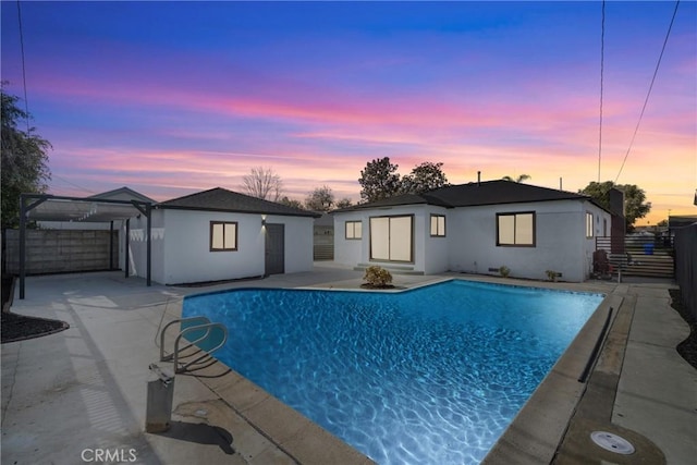 pool at dusk with a patio