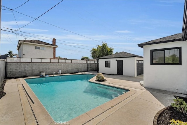 view of swimming pool with an outdoor structure and a patio area