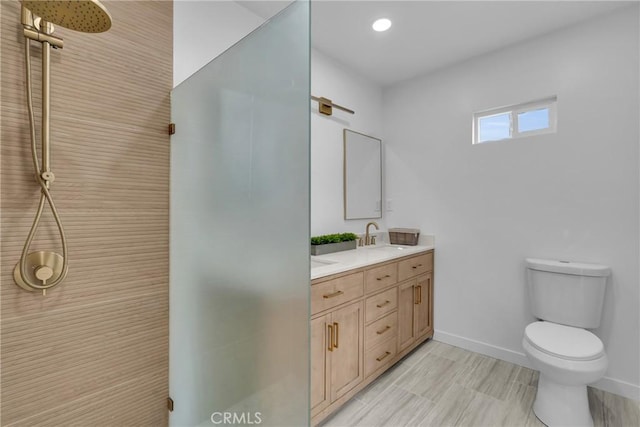 bathroom with vanity, toilet, and a shower