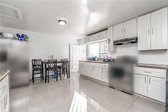 kitchen featuring white cabinetry, sink, and light tile patterned floors